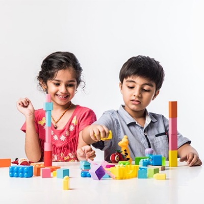 cute little indian asian kids sitting and playing with colourful block toys